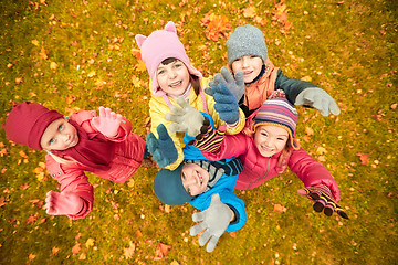 Image showing happy children waving hands in autumn park