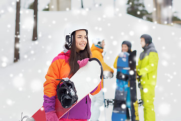 Image showing happy friends in helmets with snowboards