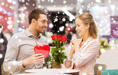 Image showing happy couple with present and flowers in mall