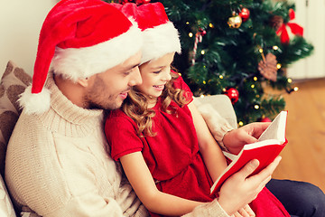 Image showing smiling father and daughter reading book