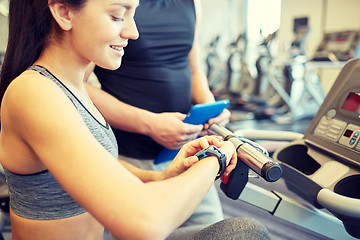 Image showing close up of woman setting heart-rate watch at gym