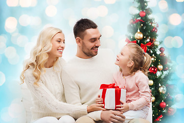 Image showing happy family with gift box over christmas lights