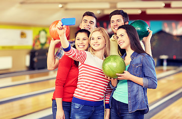 Image showing happy friends with smartphone in bowling club