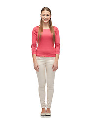 Image showing smiling young woman in pink pullover and jeans