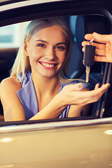 Image showing happy woman getting car key in auto show or salon