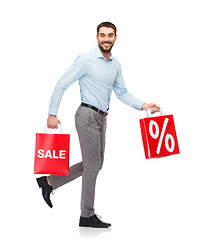 Image showing smiling man walking with red shopping bag