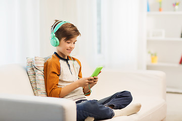 Image showing happy boy with smartphone and headphones at home