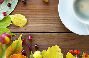 Image showing close up of coffee cup on table with autumn leaves