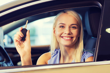 Image showing happy woman getting car key in auto show or salon