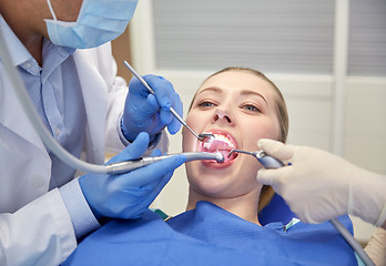 Image showing close up of dentist treating female patient teeth