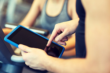 Image showing close up of trainer hands with tablet pc in gym