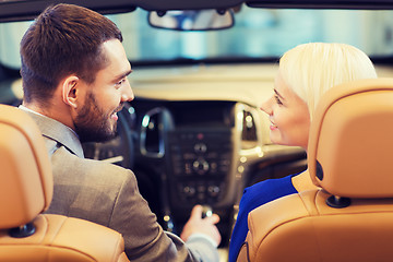 Image showing happy couple sitting in car at auto show or salon