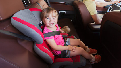 Image showing happy child sitting in car seat and father driving