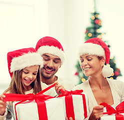 Image showing happy family in santa helper hats with gift boxes