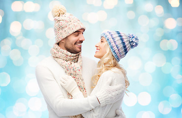 Image showing happy couple in winter clothes hugging over lights