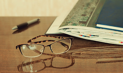 Image showing Glasses and Newspapers on the table surface.