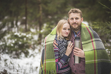 Image showing Young couple in a warm blanket with thermos flask