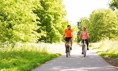 Image showing happy couple riding bicycle outdoors