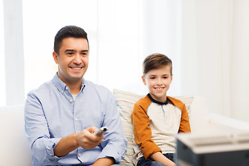 Image showing smiling father and son watching tv at home
