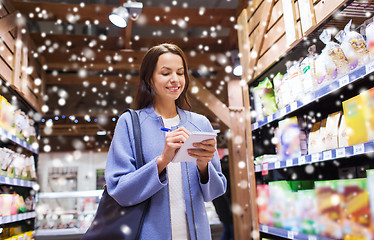 Image showing happy woman with notepad in market