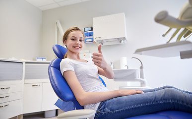 Image showing happy patient girl showing thumbs up at clinic