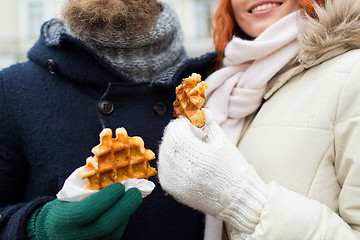 Image showing close up of happy couple eating waffles outdoors