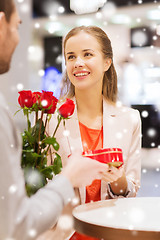 Image showing happy couple with present and flowers in mall