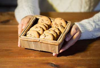 Image showing close up of woman with oat cookies at home