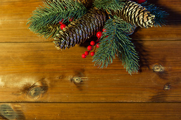 Image showing close up of fir branch with cones on wooden table