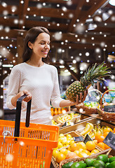 Image showing happy young woman with food basket in market