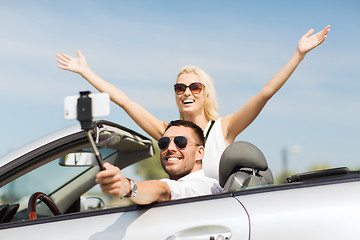 Image showing happy couple in car taking selfie with smartphone