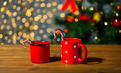 Image showing christmas candy canes and cups on wooden table