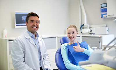 Image showing happy male dentist with woman patient at clinic