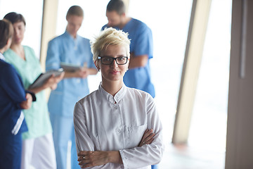 Image showing female doctor with glasses and blonde hairstyle standing in fron