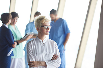 Image showing female doctor with glasses and blonde hairstyle standing in fron