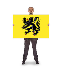 Image showing Smiling businessman holding a big card, flag of Flanders