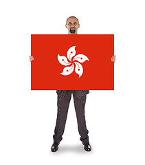 Image showing Smiling businessman holding a big card, flag of Hong Kong