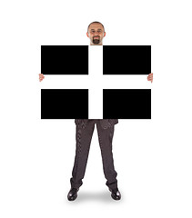 Image showing Smiling businessman holding a big card, flag of Cornwall