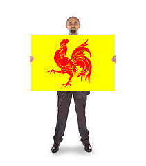 Image showing Smiling businessman holding a big card, flag of Wallonia