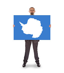 Image showing Smiling businessman holding a big card, flag of Antarctica