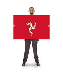 Image showing Smiling businessman holding a big card, flag of Isle of Man