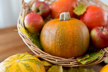 Image showing close up of pumpkins in basket on wooden table