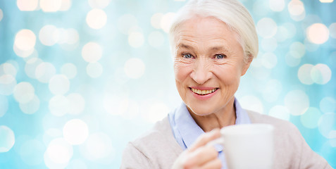 Image showing happy senior woman with cup of tea or coffee