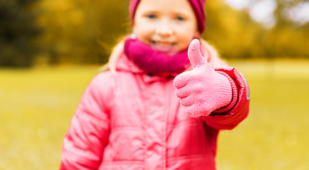 Image showing happy girl showing thumbs up outdoors