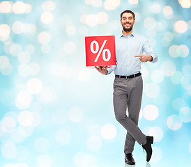 Image showing smiling man with red shopping bag over blue lights