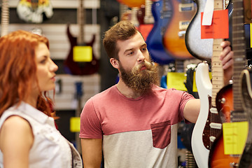 Image showing couple of musicians with guitar at music store