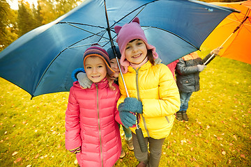 Image showing happy children with umbrella in autumn park