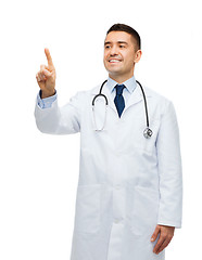 Image showing smiling male doctor in white coat pointing finger