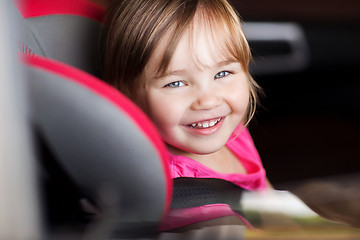 Image showing happy little girl sitting in baby car seat