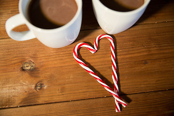 Image showing christmas candy canes and cups on wooden table